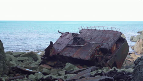 rms mulheim shipwreck lying by the rocks near the calm sea - medium shot