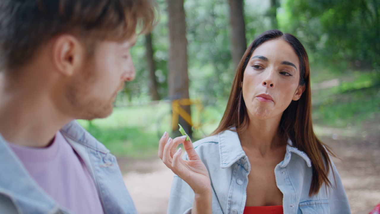 Woman enjoying snack picnic sunny forest closeup. Happy brunette talking friend