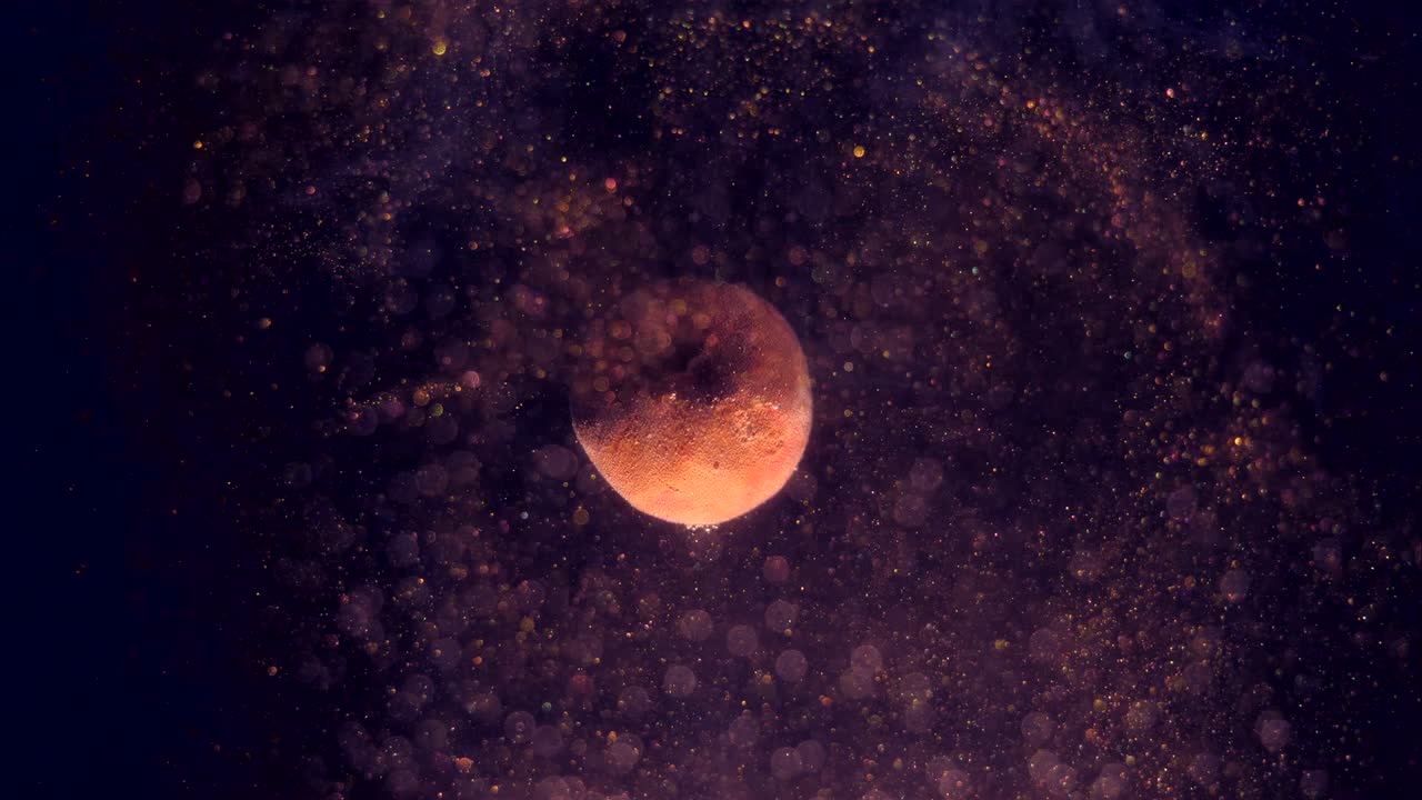rotación de un pequeño planeta alrededor de su eje. espumoso polvo espacial dorado girando al azar y brillante. partículas bokeh en el frente.