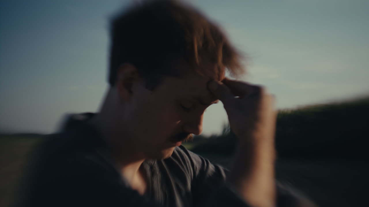 Man in prayer or deep contemplation outdoors at dusk