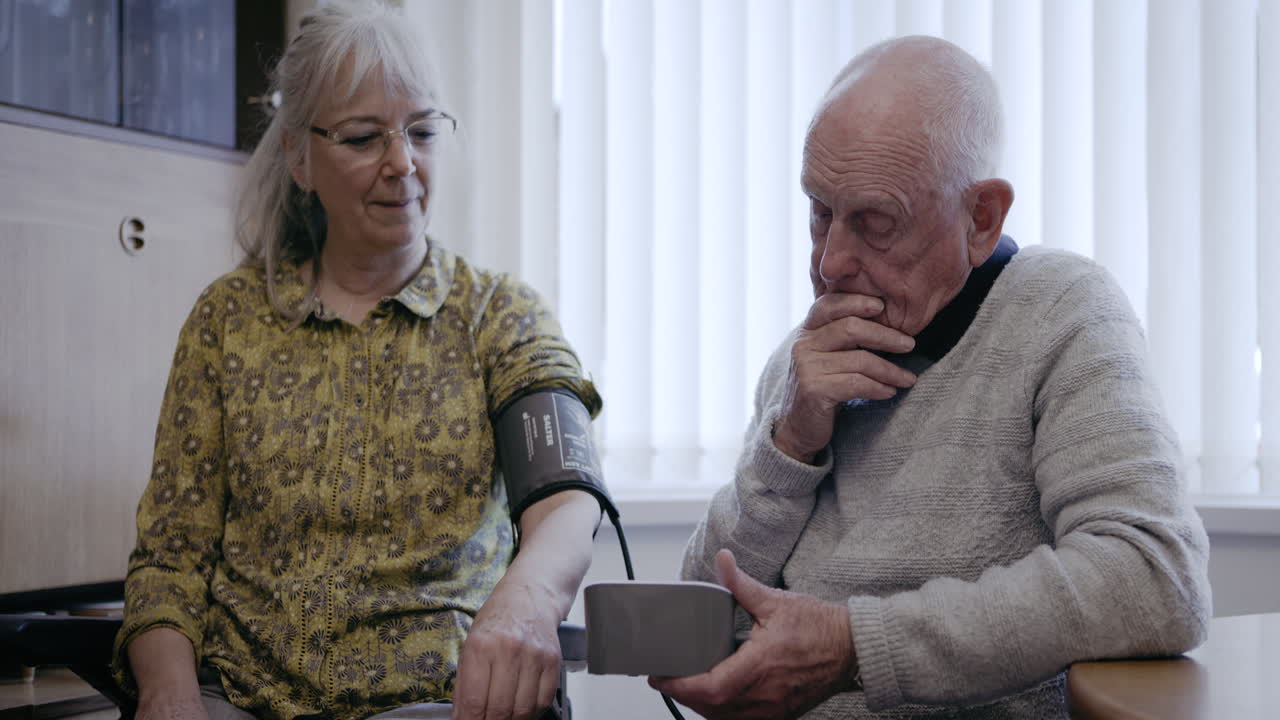 Elderly man having his blood pressure checked at home