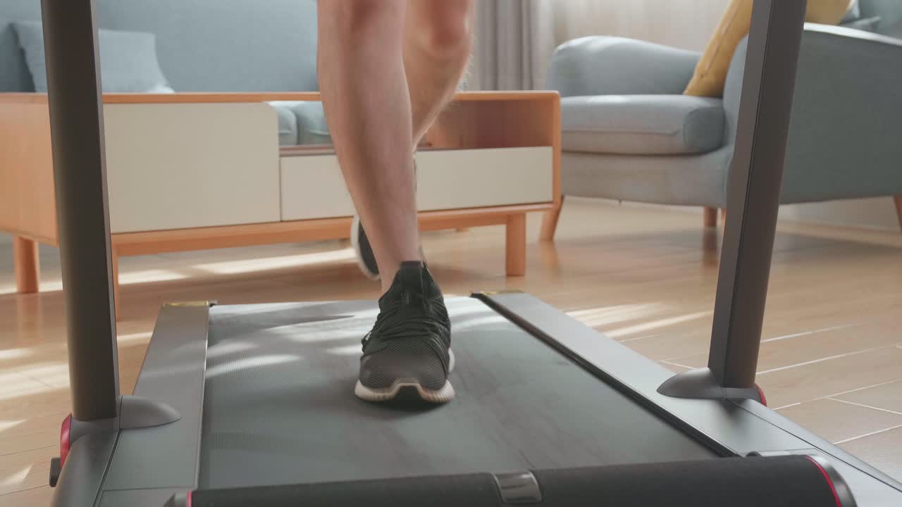 Front View Of Legs Of Man Running On A Treadmill At Home