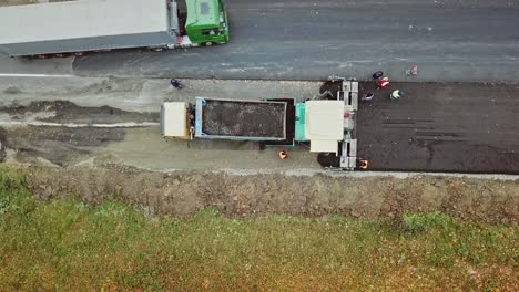 construction work for road. pavement machine laying fresh asphalt during highway construction
