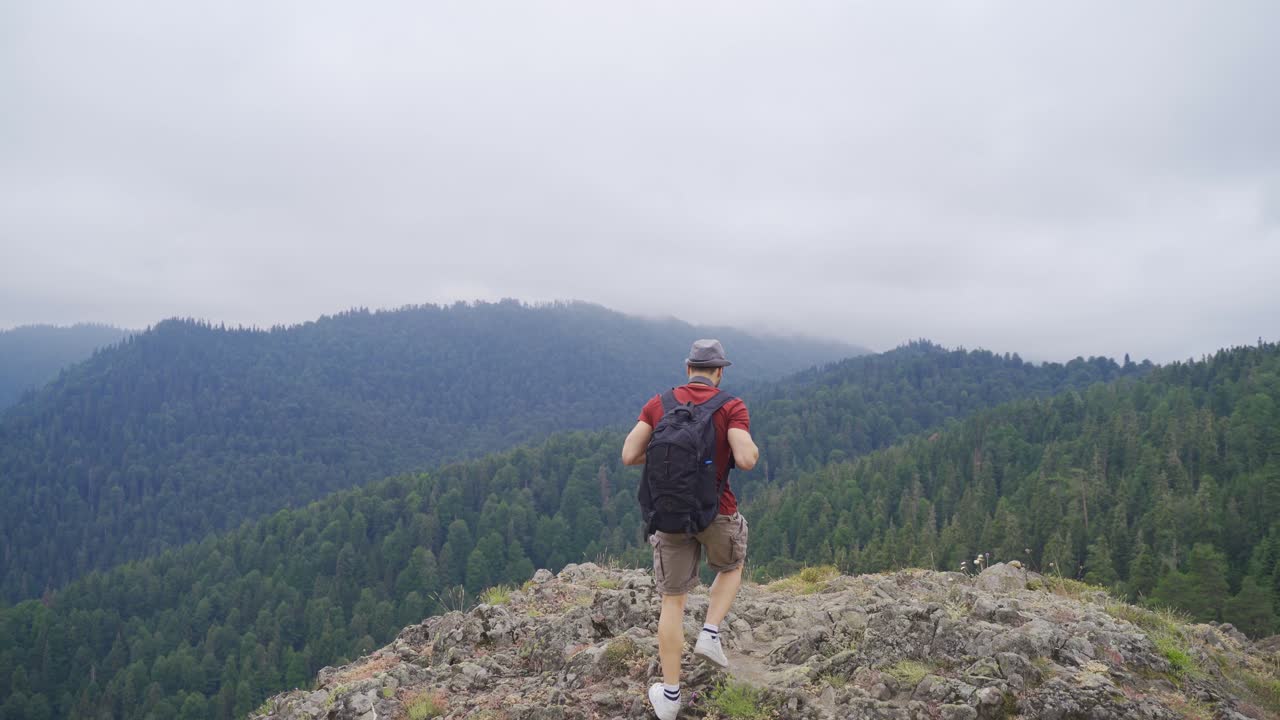 hombre caminando en la cima de las montañas.