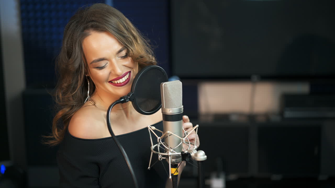 Bella ragazza canta in un microfono in uno studio di registrazione. Concerto di musica retrò in un club
