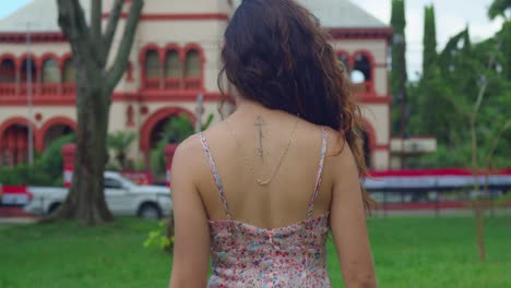 chica de cabello rizado caminando hacia un castillo en la isla caribeña de trinidad y tobago