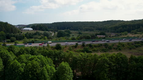 panorama view of traffic on freeway in poland with green trees and hills in nature