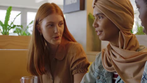 young adult female friends hanging out in a cafe