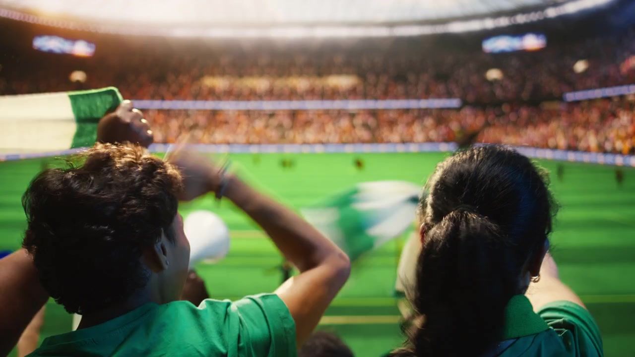 Primer plano de aficionados de fútbol emocionados en las gradas del estadio levantando los puños