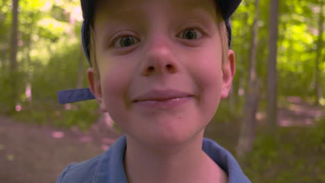 outdoor portrait of a happy boy showing off his missing teeth