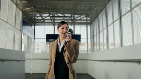 businesswoman using phone at train station