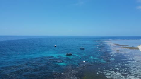 Ver-Moviéndose-A-Través-De-Una-Barrera-De-Coral-Hacia-Los-Barcos-De-Buceo-Amarrados-En-Las-Aguas-Azules-De-Una-Isla-Tropical