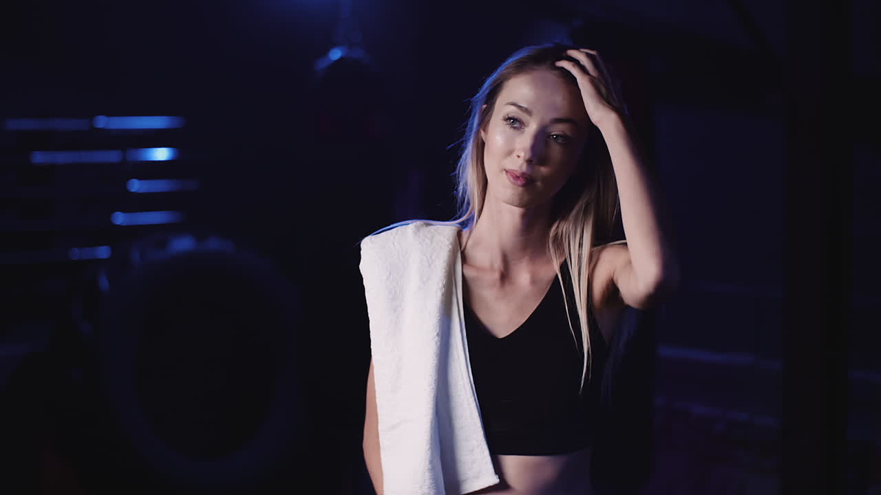 피트니스 스튜디오에서 긴 머리를 통해 손을 움직이는 아름다운 여성 운동선수의 슬로우 모션