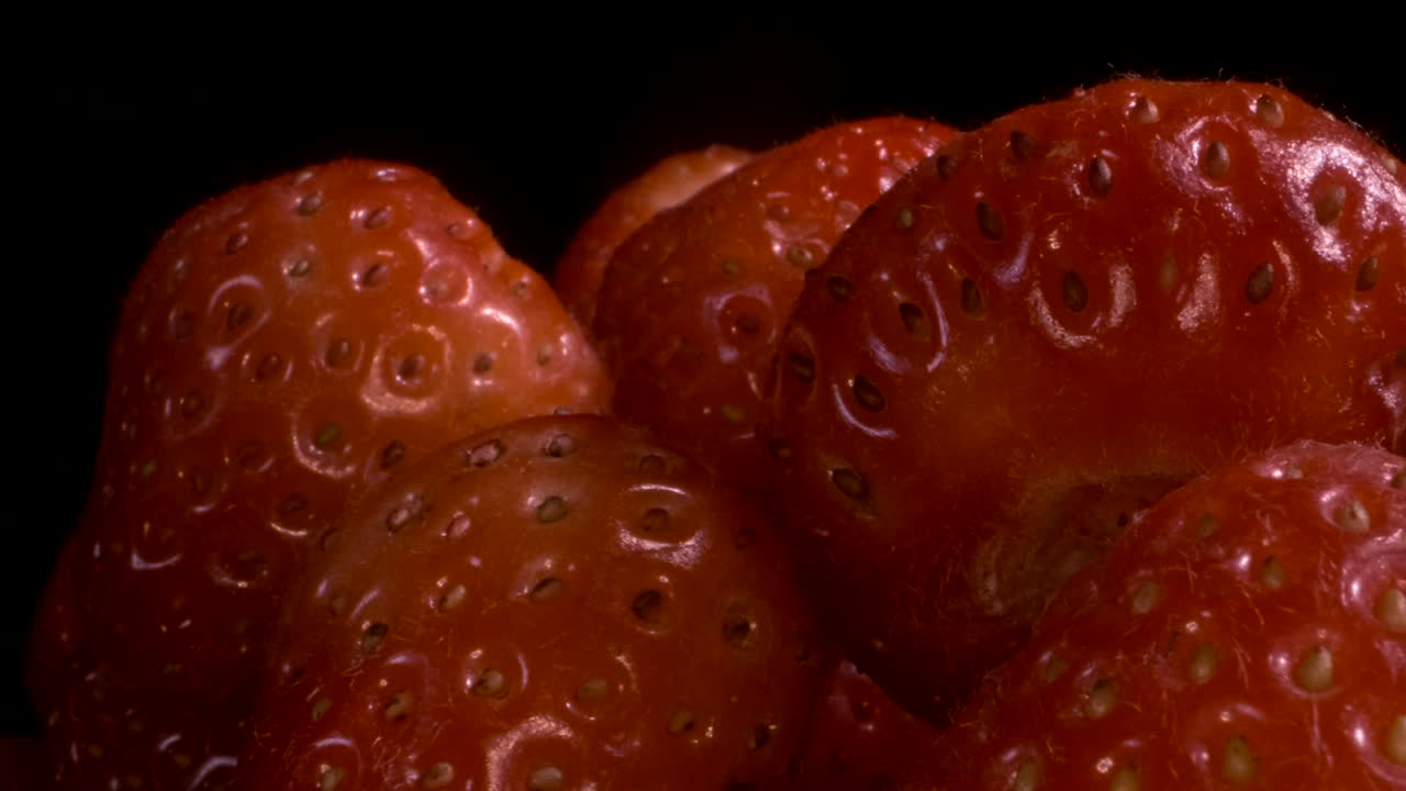 girar las fresas rojas sobre un fondo negro. primer plano, rotación de la cámara 360 grados.