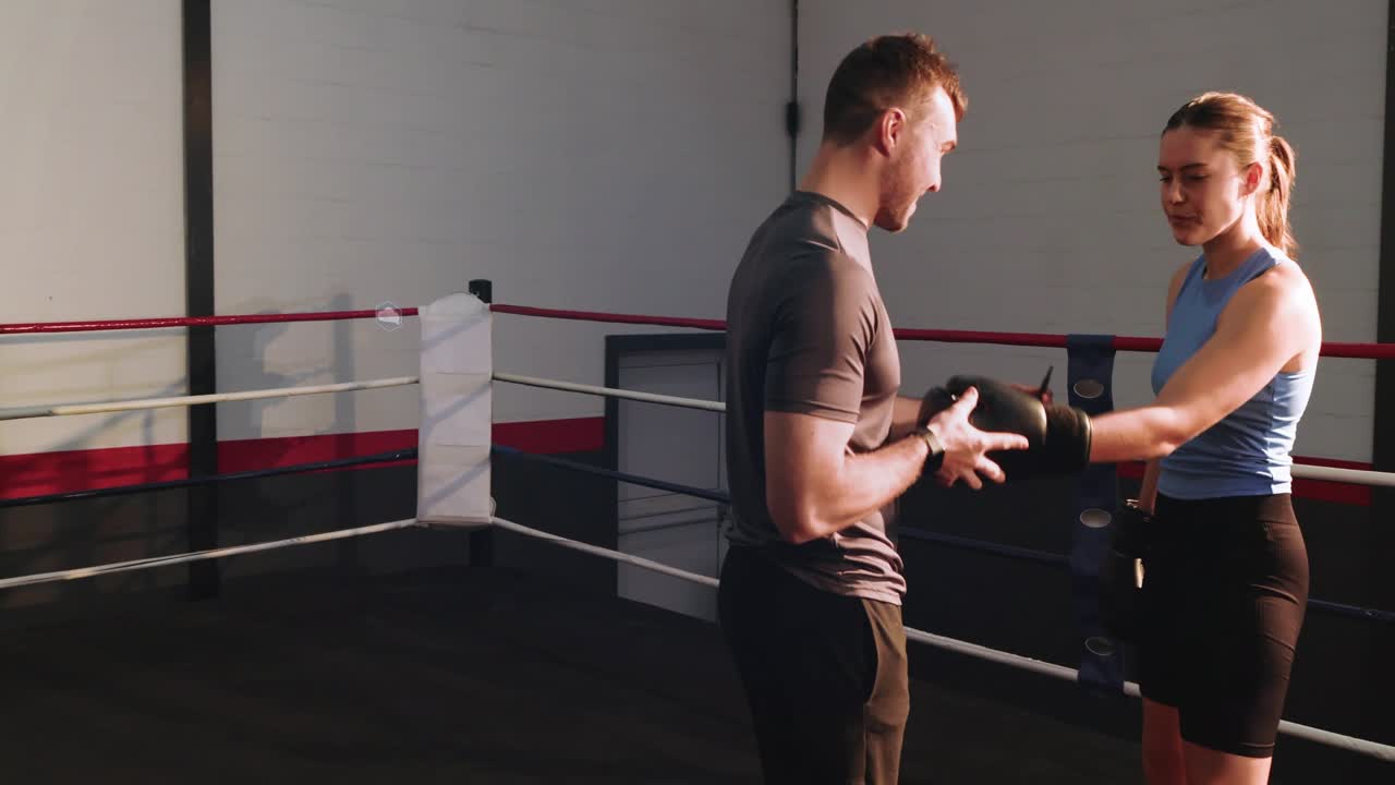 Boxer extending wrapped hand, coach inspecting and fastening glove while data overlays ensuring fit