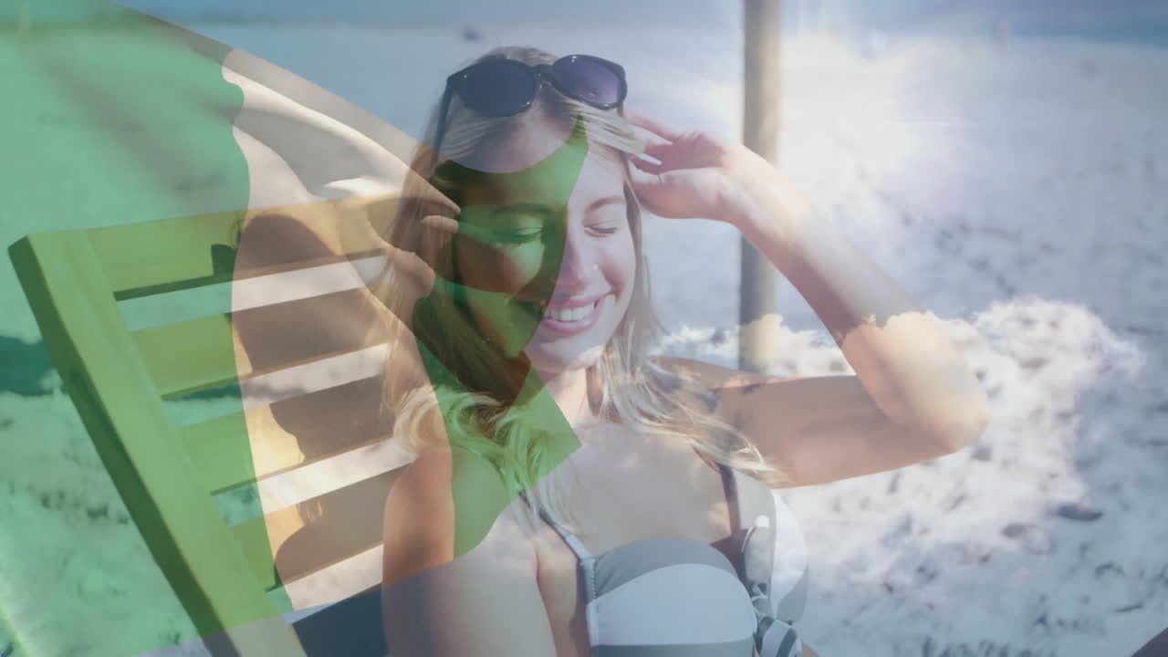 Relaxing on beach, woman with Irish flag animation overlay, smiling contentedly