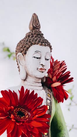 buddha statue with red flowers