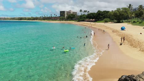 vista aérea baja de niños jugando en la playa de mayo en maui, hawaii