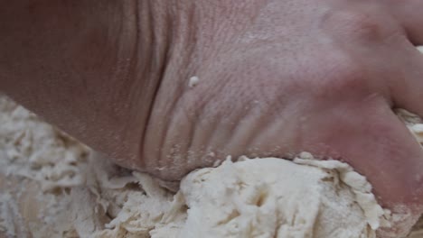 chef molds the pizza dough in a deep plate, on a wooden table