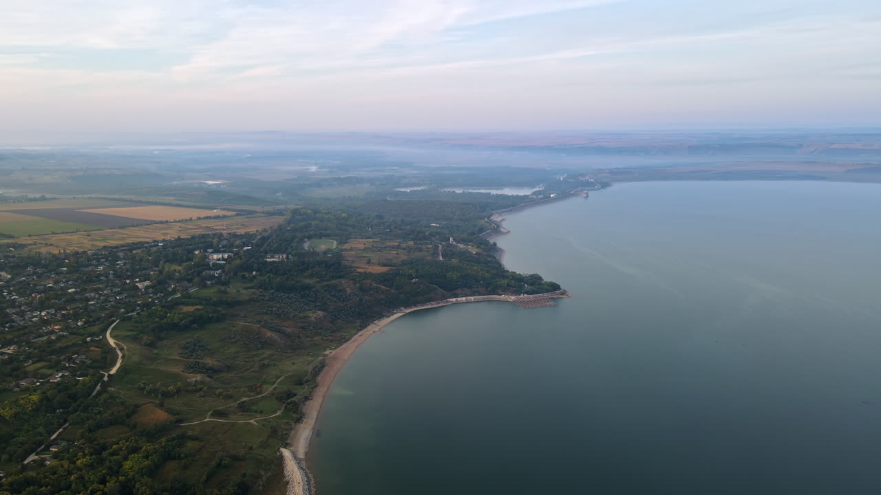 Aerial drone view of the Duruitoarea natural reservation in Moldova. River and fog in the air, hills and fields, village with roads and greenery