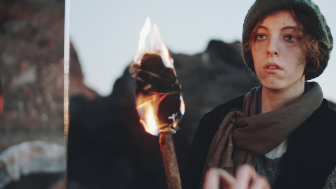 mujer sosteniendo una antorcha y mirándose en el espejo en un mundo distópico