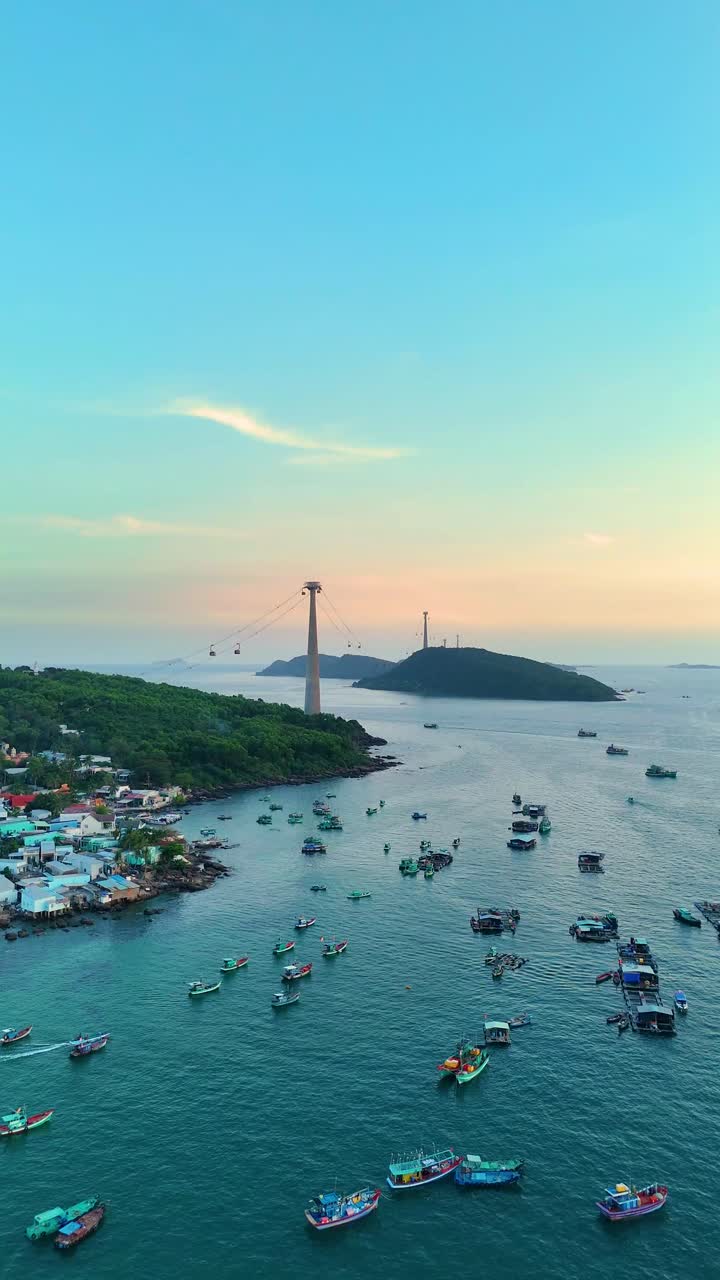 Vertical drone shot of a fishing village with cable cars and fish boats during the day in Sunset Town, Phu Quoc Island, Vietnam.