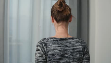 Silhouette-Of-Young-Woman-Coming-Up-To-The-Window-Unveiling-Curtains-And-Looking-Out-Of-Window