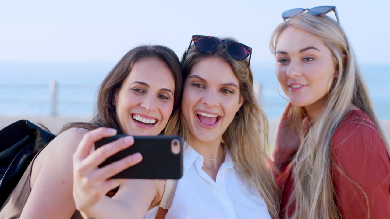 mujeres, teléfonos y selfies en la playa para las redes sociales