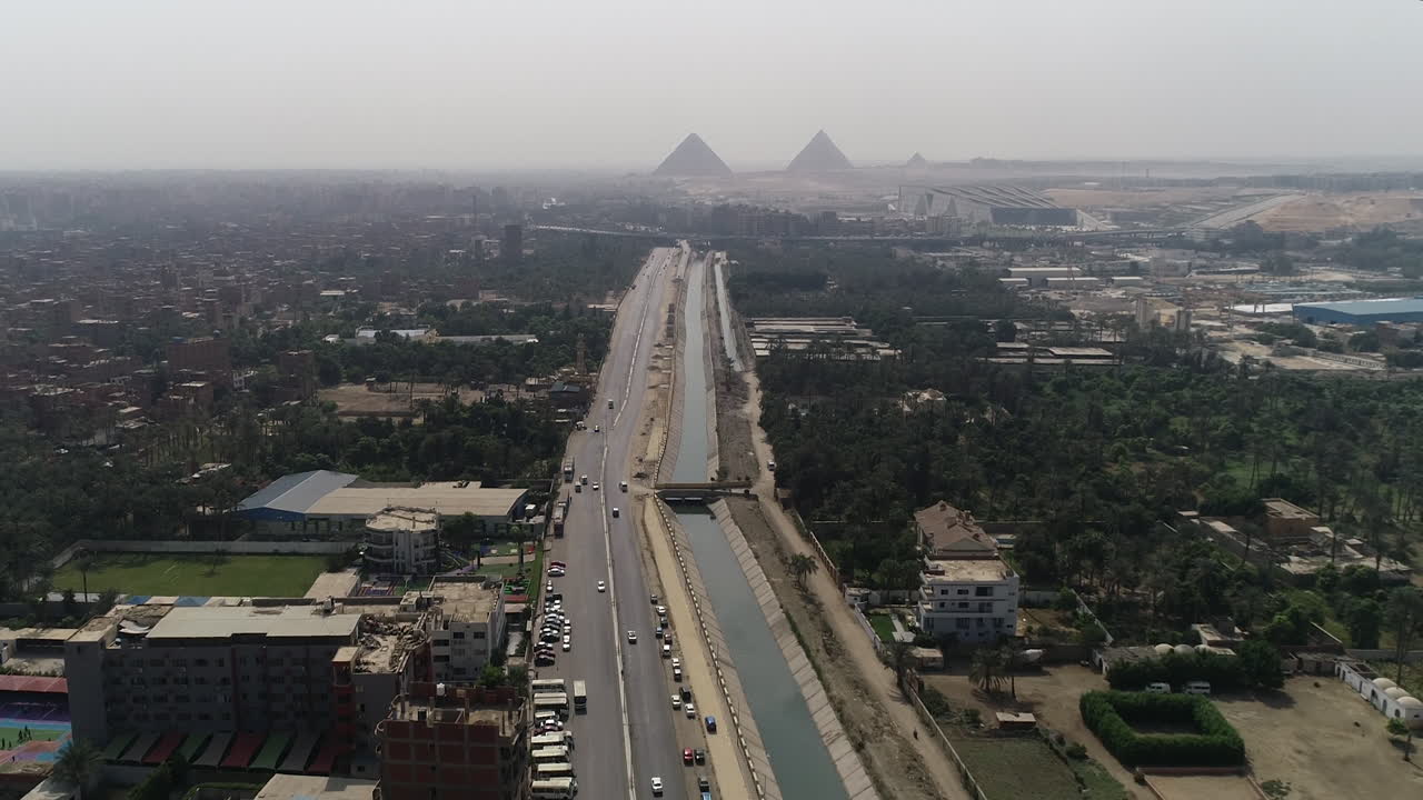 pista de disparo aéreo hacia fuera y subiendo para las pirámides de egipto en giza en el fondo de una rama del río nilo en el primer plano rama maryotya que viene a lo largo del camino desde la fuente del nilo