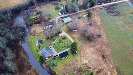 birds-eye view of a countryside house next to a river in estonia in autumn