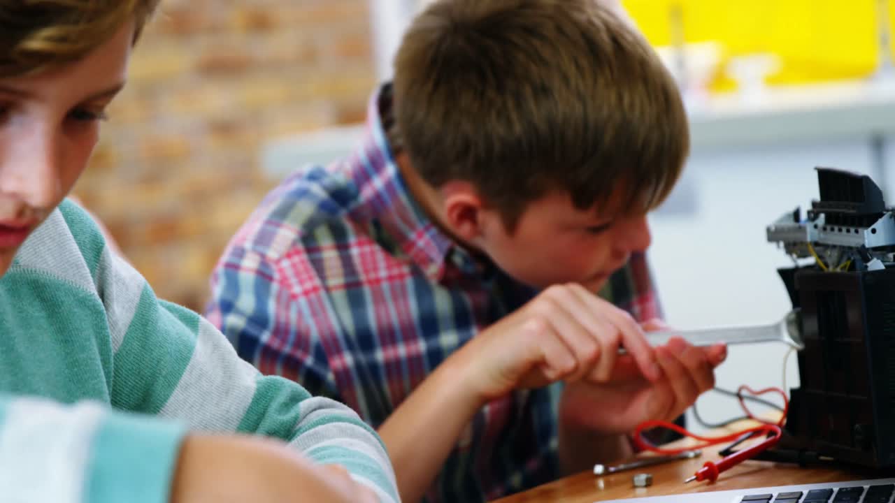 escolares trabajando en un proyecto electrónico en el aula