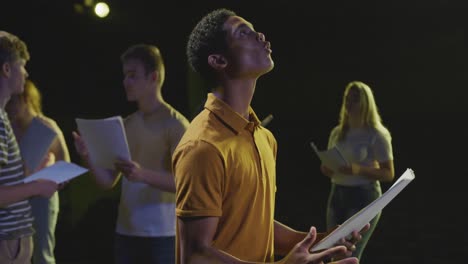 students preparing before a high school performance in an empty school theater