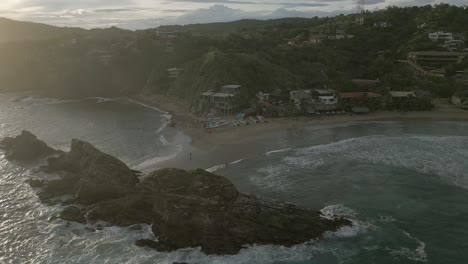 aerial orbits elephant beach at mazunte mx in misty sunset sun beam