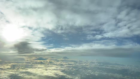 vista aérea desde una cabina de jet de un cielo invernal lleno de nubes coloridas, colores amarillo y blanco, antes del atardecer