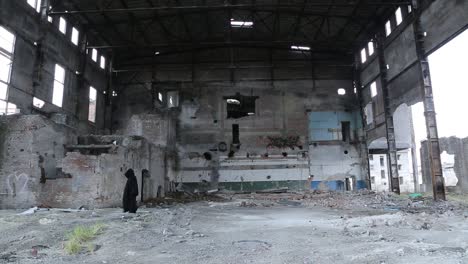 ghost in destroyed building. ghost in black cloak walking throug destroyed building