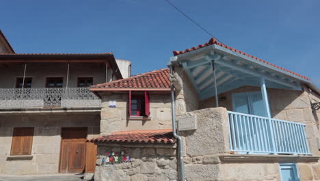 traditional stone house with blue accents under clear skies in pontevedra, galicia, spain