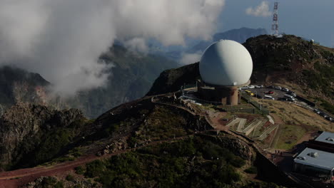 pico arieiro, madeira: aerial view in a circle towards the radar station that is in the area and with the background of the nearby clouds