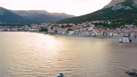 Lancha-Rápida-Navegando-Hacia-La-Hermosa-Ciudad-Turística-Durante-La-Puesta-De-Sol-En-Baska,-Isla-Krk-En-Croacia