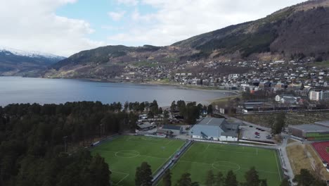 two soccer fields, swimming arena and racetrack at voss norway - vangswater lake in the background