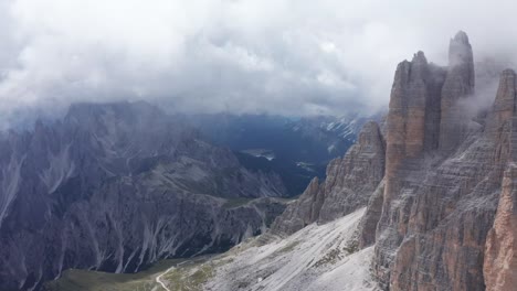 Toma-Aérea-De-Drones-De-Nubes-Misteriosas-Que-Se-Ciernen-Alrededor-De-Tre-Cime-Spires-En-Los-Dolomitas