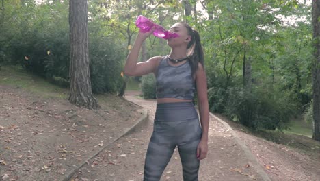 Mädchen-Trinkt-Wasser-Aus-Einer-Flasche,-Während-Sie-Sich-Nach-Einem-Training-Ausruht