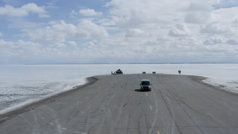 Turistas-En-El-Paisaje-épico-De-Bonneville-Salt-Flats-Road-En-Utah,-órbita-Aérea