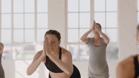 young pregnant caucasian woman in yoga class practicing standing forward bend pose enjoying healthy lifestyle group exercising in fitness studio