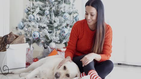 Lachende-Junge-Frau-Mit-Ihrem-Hund-Zu-Weihnachten