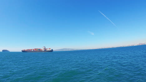 A-huge-container-ship-off-the-shore-of-a-port-in-the-Pacific-Ocean---slow-motion