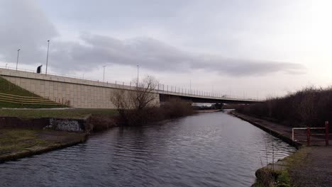 Freight-truck-driving-overpass-bridge-crossing-over-vibrant-canal-urban-scene-waterway-regeneration