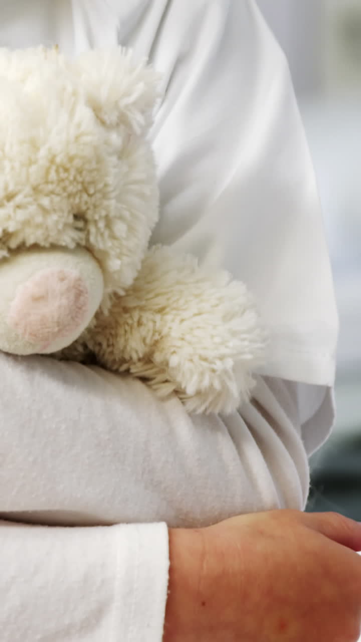 Ragazza a mezzo busto che tiene un orsetto di peluche