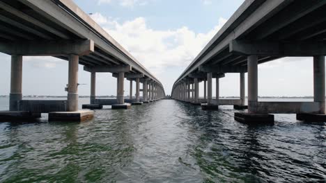 Cinematic-drone-shot-flying-between-to-lanes-of-coastal-highway-causeway