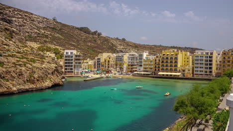 Timelapse-of-ferries-and-boats-entering-port-to-Xlendi-Beach,-Malta