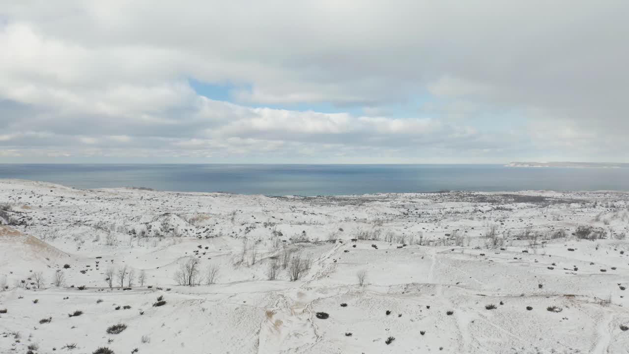 Drone flyr bort fra snødekte sanddyner i Michigan, USA.